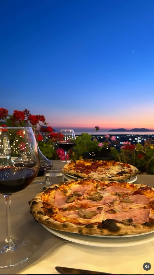 Pizza and wine on a hilltop terrace at sunset overlooking the Adriatic